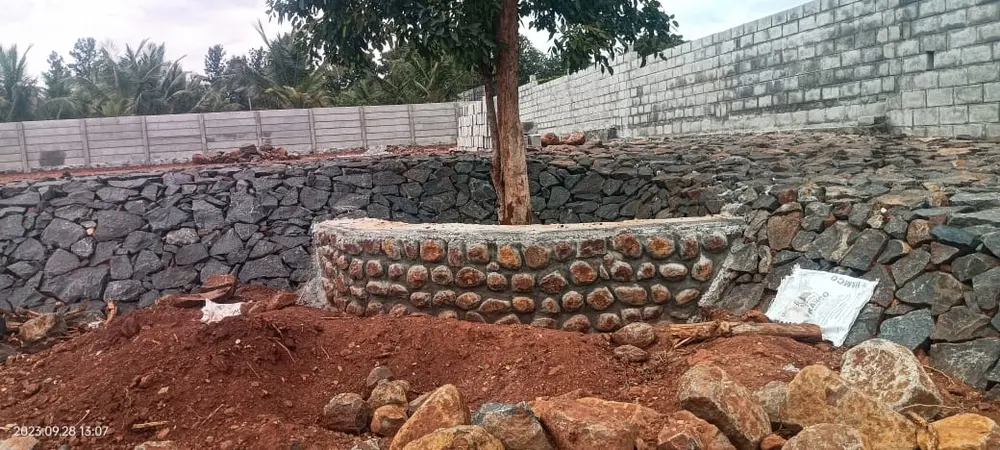 Black stone garden wall around tree